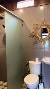 ein Badezimmer mit einem WC, einem Spiegel und einem Waschbecken in der Unterkunft HK VILLA'S in Sembalun Lawang