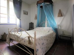 um quarto com uma cama branca e cortinas azuis em Maison Port-Vendres, 7 pièces, 5 personnes - FR-1-309-369 em Port-Vendres