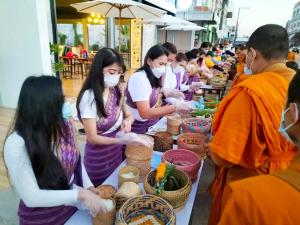 un grupo de personas usando máscaras faciales preparando comida en โรงแรมเรือนไทย 1 (Thai Guest House), en Ban Don Klang
