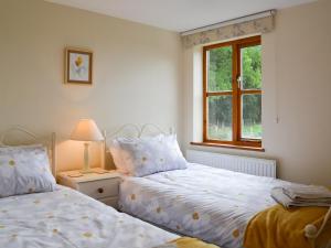 a bedroom with two beds and a window at Elesa Cottage in Elsing