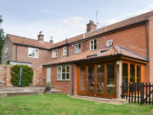 an extension to a brick house with glass doors at Elesa Cottage in Elsing