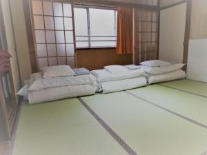 2 letti posti in una stanza con finestra di Yamamoto Ryokan a Fukuoka