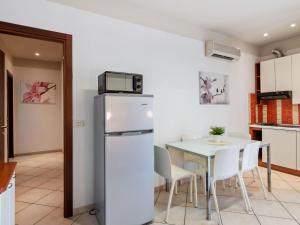 a kitchen with a table and a microwave on top of a refrigerator at Modern Apartment in Rimini with Balcony in Rimini