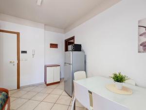 a kitchen with a table and a refrigerator in a room at Modern Apartment in Rimini with Balcony in Rimini