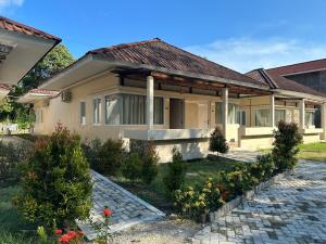 uma casa com um caminho de pedra à sua frente em Vogelkopf Resort em Tapokreng