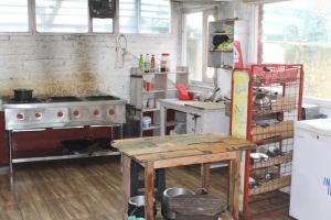 a kitchen with a stove and a table in it at THE GROOVE GARDEN DHANOLTi in Dhanaulti