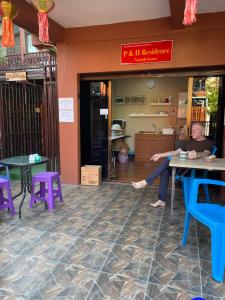 uma mulher sentada numa mesa num restaurante em P & H Residence NorthGate em Chiang Mai