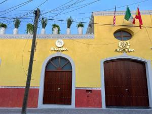 un edificio amarillo con dos puertas y banderas. en Hotel Arthemisa, en Guanajuato