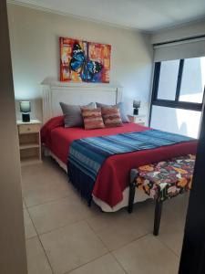 1 dormitorio con 1 cama con manta roja y azul en En Goya en Los Reartes