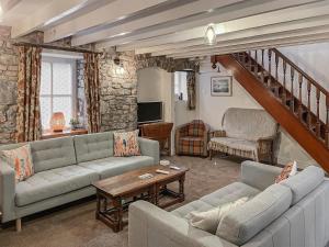 a living room with two couches and a staircase at Priory Stile in Haverfordwest
