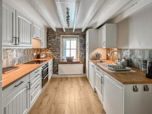 哈佛威斯特的住宿－Priory Stile，一间铺有木地板的大厨房,配有白色的橱柜