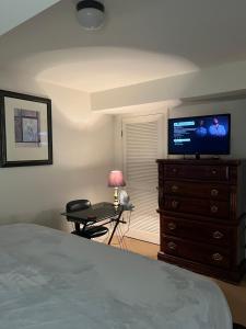 a bedroom with a bed and a desk with a television at Atkins Investments Inc. Swanhaven in Richmond
