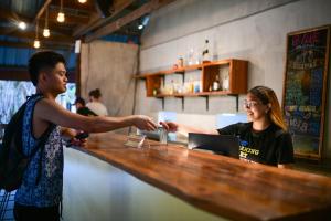 a man handing a woman a drink at a bar at Abraham Bohol in Panglao Island