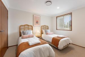 a bedroom with two beds and a window at Shell Cove Coastal Haven in Shellharbour
