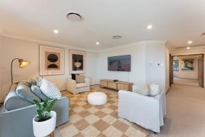 a living room with a blue couch and two chairs at Shell Cove Coastal Haven in Shellharbour