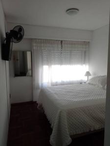 een slaapkamer met een wit bed en een raam bij Playa Mansa Parada Uno in Piedras Blancas