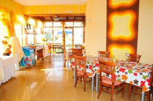 a dining room with a table and chairs and a kitchen at Hotel Apolis in Sozopol