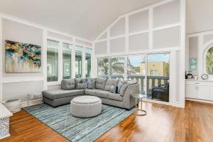 a living room with a couch and a table at Massive Beach Home w Stunning Rooftop, Parking, Spa, AC & Bay Views! in San Diego