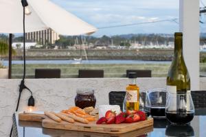 a table with a bottle of wine and a plate of food at Massive Beach Home w Stunning Rooftop, Parking, Spa, AC & Bay Views! in San Diego