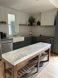 a kitchen with a table in the middle of it at Cozy 2 bedroom cottage - Newly renovated, perfect location for best of Ballarat in Ballarat
