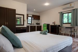 a bedroom with a large bed with a stuffed animal on it at Lanta School Beach Resort in Phra Ae beach