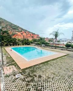 uma grande piscina com uma montanha ao fundo em Comodo Apartamento frente al Aeropuerto Maiquetia em Catia La Mar