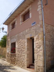 a stone building with a door and a window at Los Olmos Holiday Home in Fuentidueña