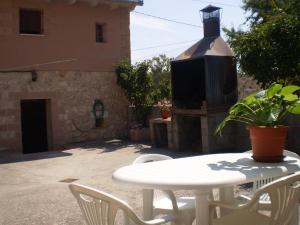 une table et des chaises blanches devant un bâtiment dans l'établissement Los Olmos Holiday Home, à Fuentidueña