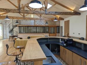 une grande pièce avec une table et des chaises en bois dans l'établissement Maison lumineuse avec cuisine équipée, 3 chambres avec SDE & WC privatifs, garage et Wifi - Jarnac - FR-1-653-246, à Jarnac