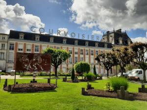 un grand bâtiment avec une enseigne devant dans l'établissement Maison lumineuse avec cuisine équipée, 3 chambres avec SDE & WC privatifs, garage et Wifi - Jarnac - FR-1-653-246, à Jarnac