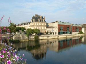 a large building next to a body of water at Loft lumineux avec cuisine équipée et circuits truffes - Centre-ville Jarnac - FR-1-653-248 in Jarnac