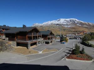 ein großes Gebäude mit einem schneebedeckten Berg im Hintergrund in der Unterkunft Appartement Huez, 2 pièces, 5 personnes - FR-1-405-341 in Huez