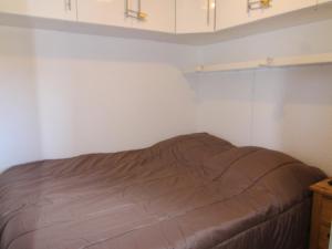 Bett in einem Zimmer mit weißen Wänden und Schränken in der Unterkunft Appartement Huez, 2 pièces, 5 personnes - FR-1-405-341 in Huez