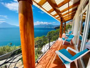 porche con sillas y vistas al océano en Villa Palopo, en Santa Catarina Palopó