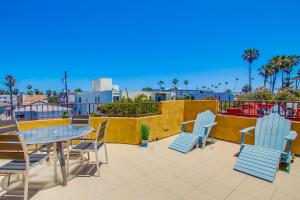 um pátio com uma mesa, cadeiras e palmeiras em Rooftop Paradise w Private Patio, Garage & AC em San Diego