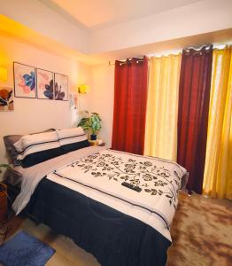 ein Schlafzimmer mit einem großen Bett mit farbenfrohen Vorhängen in der Unterkunft Azure Stay by Marjorenz in Manila