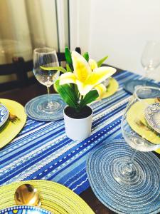 einem Tisch mit einer gelben Blume auf einem blauen und weißen Tischtuch in der Unterkunft Azure Stay by Marjorenz in Manila