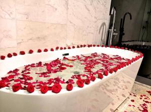 a bath tub filled with red roses in a bathroom at The Platinum Suites KLCC in Kuala Lumpur
