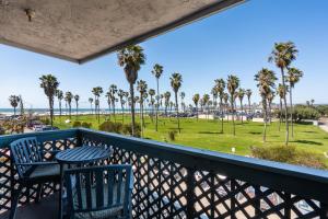 a balcony with a table and chairs and a view of the beach at Belmont Modern - Ocean View, Pet Friendly, Patio in San Diego