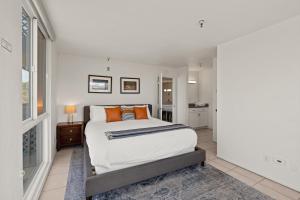 Belmont Modern - Ocean View, Pet Friendly, Patio في سان دييغو: غرفة نوم مع سرير كبير مع وسائد برتقالية