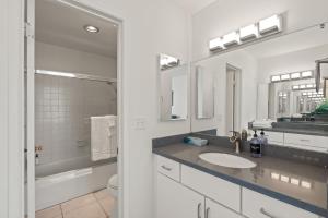 a white bathroom with a sink and a mirror at Belmont Modern - Ocean View, Pet Friendly, Patio in San Diego