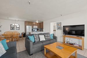 uma sala de estar com um sofá e uma mesa em Belmont Modern - Ocean View, Pet Friendly, Patio em San Diego