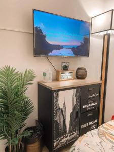 a flat screen tv on top of a black entertainment center at La bella tagaytay- Casa Raffa in Tagaytay