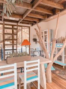 uma mesa com cadeiras e uma árvore num quarto em La bella tagaytay- Casa Raffa em Tagaytay