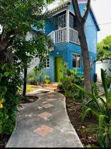 a blue house with a yellow door and trees at Casa Catalina in San Pedro