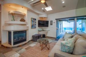 a living room with a couch and a fireplace at Stunning Oceanfront Boardwalk Condo - Spa, Steps2Beach, Parking & Fast Wifi! in San Diego