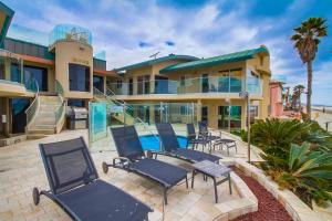 a house with chairs and a swimming pool at Stunning Oceanfront Boardwalk Condo - Spa, Steps2Beach, Parking & Fast Wifi! in San Diego