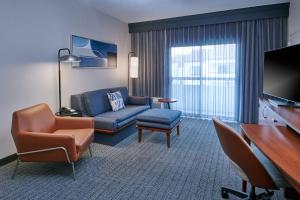 a living room with a couch and a chair at Courtyard by Marriott Detroit Livonia in Livonia