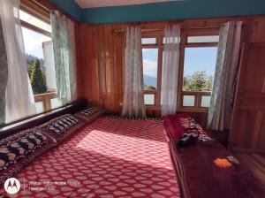 a room with a couch in front of two windows at KACEY HOMESTAY in Pedong