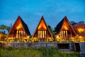 a resort with three pointed roofs at night at The Pyramid Ubud River Villas in Gianyar